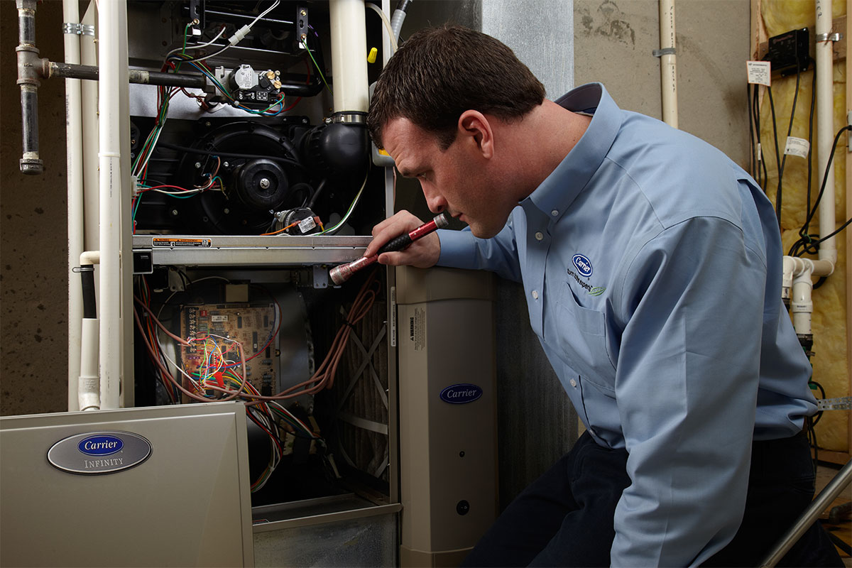 Furnace repair tech examines system in Pickerington